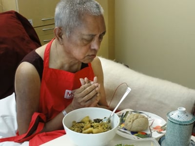 Rinpoche offering food while in hospital in Australia after manifesting a stroke in April 2011. Photo: Ven. Holly Ansett.