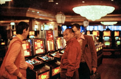 Lama Yeshe with the &quot;one-arm-bandits&quot; (and Ven. John Feuille) at the MGM in Reno, Nevada, 1977. Photo by Anila Ann McNeil. 