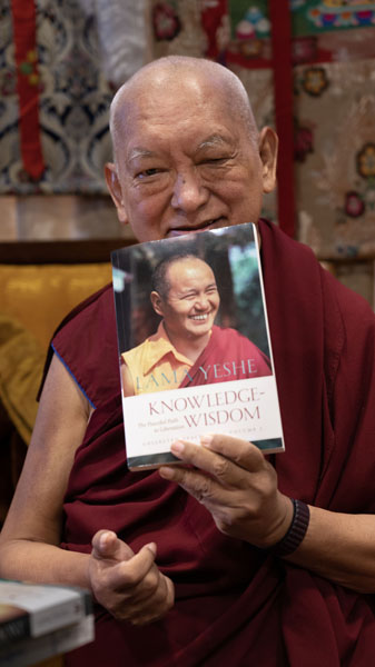 Lama Zopa Rinpoche with Knowledge-Wisdom book, March 2023. Photo: Ven. Roger Kunsang.