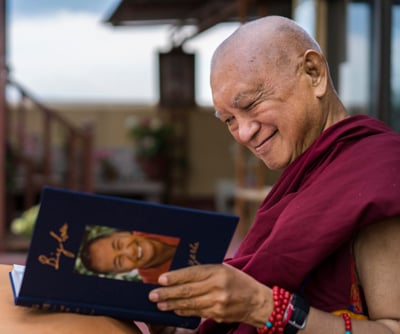Lama Zopa Rinpoche enjoying his copy of Big Love, Kopan Monastery, Nepal, April 2020. Photo: Ven. Lobsang Sherab.